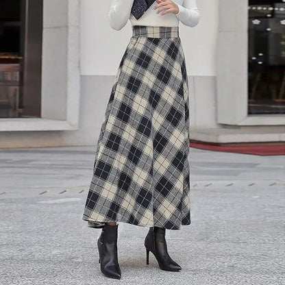 Damenmode: Eleganter, karierter Maxirock in Schwarz-Weiß mit hoher Taille, kombiniert mit schwarzen Stiefeletten. Ideal für Herbstmode und Streetstyle.