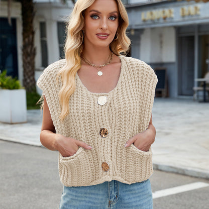 Blonde Frau in beiger Strickweste mit großen Knöpfen, lächelt in die Kamera. Modetrend, Damenmode, Herbstoutfit, lässiger Straßenstil.