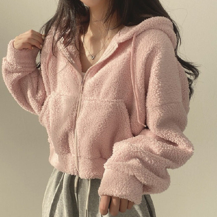 Frau in rosa Teddyfleece-Jacke mit Kapuze und Reißverschluss, lässiger Stil, gemütlich und modisch, ideal für Herbst- und Wintermode.