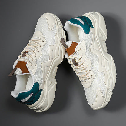 Weiße Chunky Sneaker mit dicker Sohle, braunen und grünen Akzenten auf grauem Hintergrund. Modische Turnschuhe, trendige Sportschuhe.