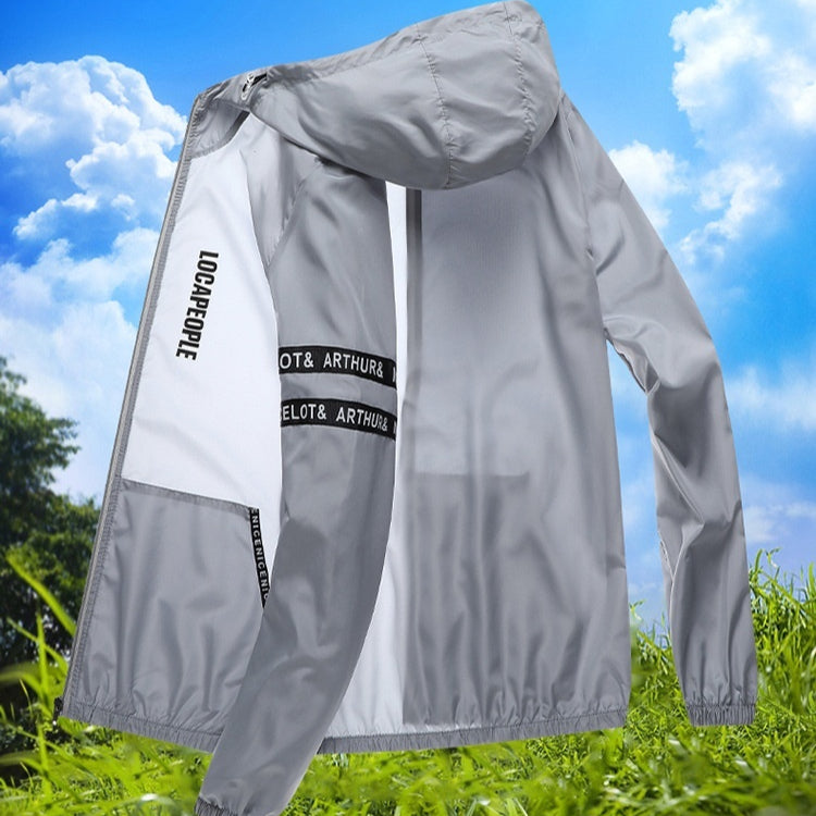 Graue Windjacke mit Kapuze, Schriftzug "LOCAPPOLE" auf dem Ärmel, vor blauem Himmel und grüner Wiese. Leichte Outdoor-Jacke für Herren.