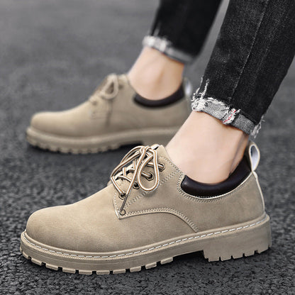 Beige Herrenschuhe aus Wildleder mit Schnürsenkeln, getragen zu schwarzen Jeans auf Asphalt. Modische, robuste Freizeitschuhe für Männer.