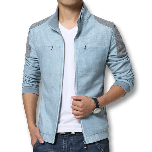 Mann in hellblauer Jeansjacke mit Reißverschluss, weißem T-Shirt und Jeans. Modische Herrenbekleidung, lässiger Stil, ideal für Freizeit.