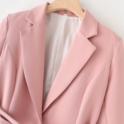 Rosa Damenblazer auf Holzkleiderbügel, elegantes Design, modische Damenbekleidung, Business-Outfit, hochwertiger Stoff, stilvolle Jacke.