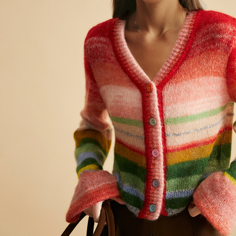 Frau trägt bunte Strickjacke mit Regenbogenstreifen und Knöpfen, modisch, Herbstmode, gemütlich, stilvoll, Damenbekleidung, Trend 2023.