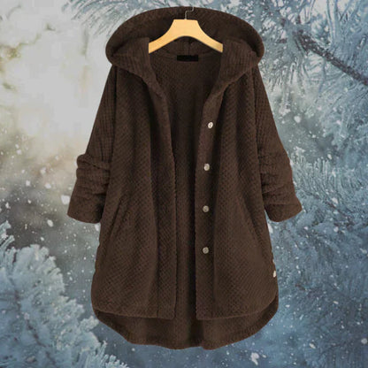 Brauner Kapuzenmantel aus Fleece mit Knöpfen, hängend vor winterlichem Hintergrund. Warme Wintermode, gemütlicher Damenmantel, stilvoll und funktional.