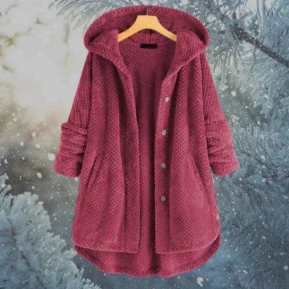 Bordeauxfarbener Damen-Fleece-Mantel mit Kapuze, Knopfleiste und Taschen, aufgehängt vor winterlichem Hintergrund mit Schneeflocken und Tannen.