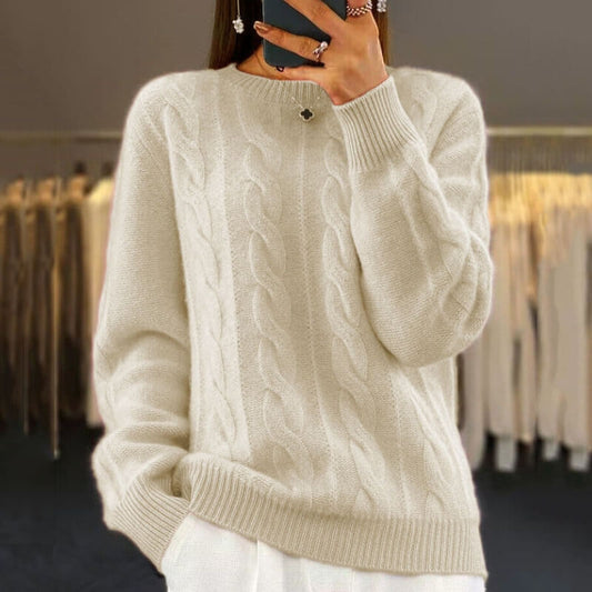 Dame in cremefarbenem Zopfmuster-Pullover, hält Smartphone, modische Kleidung im Hintergrund. Eleganter Strickpullover, Wintermode, Damenbekleidung.