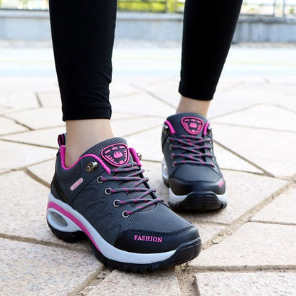 Damen Sneaker in Grau und Pink auf Gehweg, modisches Design, bequeme Sportschuhe, ideal für Freizeit und Sport, trendige Damenmode.