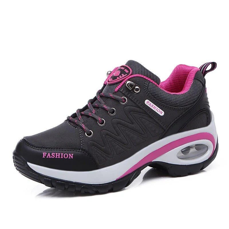 Schwarzer Damen-Sneaker mit pinken Akzenten, atmungsaktivem Mesh, rutschfester Sohle und modischem Design. Ideal für Sport und Freizeit.