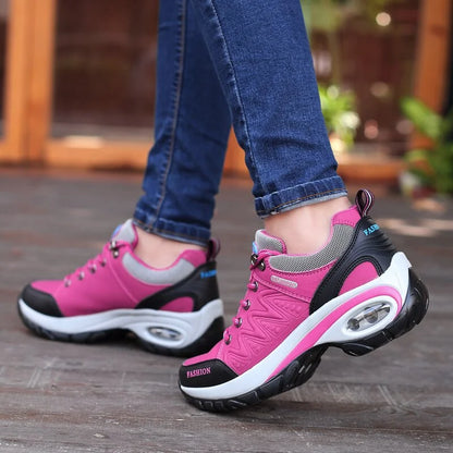 Damen Sneaker in Pink und Grau, mit Luftpolstersohle, getragen von Person in blauen Jeans. Modische Sportschuhe für Outdoor-Aktivitäten.