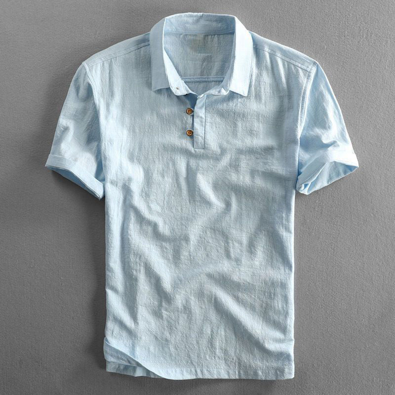 Hellblaues Leinenhemd mit kurzen Ärmeln und Knopfleiste, auf grauem Hintergrund. Sommermode, Herrenbekleidung, stilvolles Freizeitshirt.