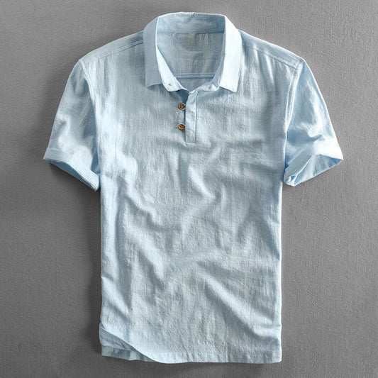 Hellblaues Leinenhemd mit kurzen Ärmeln und Knopfleiste, auf grauem Hintergrund. Sommermode, Herrenbekleidung, stilvolles Freizeitshirt.