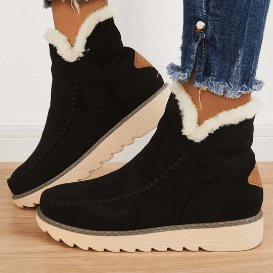 Schwarze Winterstiefel mit weißem Kunstfellfutter, seitlichem Reißverschluss und brauner Sohle. Perfekt für kalte Tage. Damenmode, warme Schuhe.