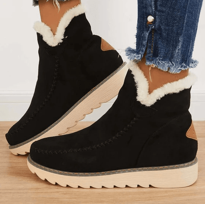 Schwarze Winterstiefel mit weißem Kunstfellfutter, seitlichem Reißverschluss und brauner Sohle. Perfekt für kalte Tage. Damenmode, warme Schuhe.
