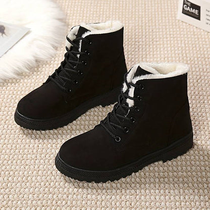 Schwarze Winterstiefel mit weißem Kunstfellfutter auf Teppichboden. Modische, warme Damenstiefel, ideal für kalte Jahreszeiten.