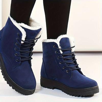 Blaue Winterstiefel mit weißem Kunstfellfutter, robustem Profil und Schnürung. Modische Damenstiefel für kalte Tage.