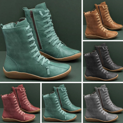 Verschiedene Damenstiefel in Grün, Braun, Rot und Grau, mit Schnürung und Reißverschluss, auf grünem Hintergrund. Modische, bequeme Herbstschuhe.