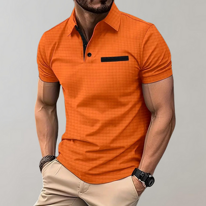 Mann in orangefarbenem Polohemd mit schwarzem Akzent, muskulös, trägt beige Hose, Armbanduhr und Armband. Mode, Herrenbekleidung, Freizeitlook.