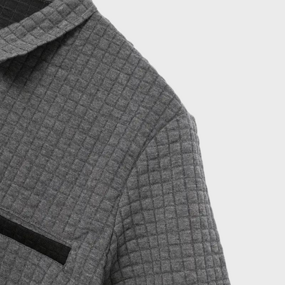 Grauer, gesteppter Wollmantel mit Karomuster und schwarzer Brusttasche. Elegante Herbstmode für Damen. Hochwertige Materialien.