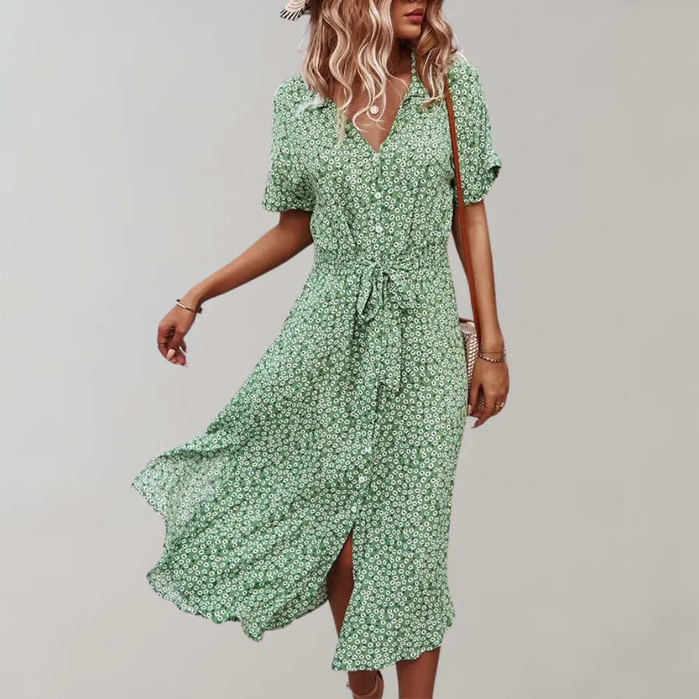 Frau in grünem Sommerkleid mit Blumenmuster, knielang, kurzärmelig, mit Gürtel. Perfekt für Freizeitmode und Sommeroutfits.