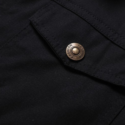 Schwarze Stofftasche mit Metallknopf, Nahaufnahme. Modischer Knopf auf dunklem Textil, Detailansicht. Hochwertige Bekleidungsaccessoires.