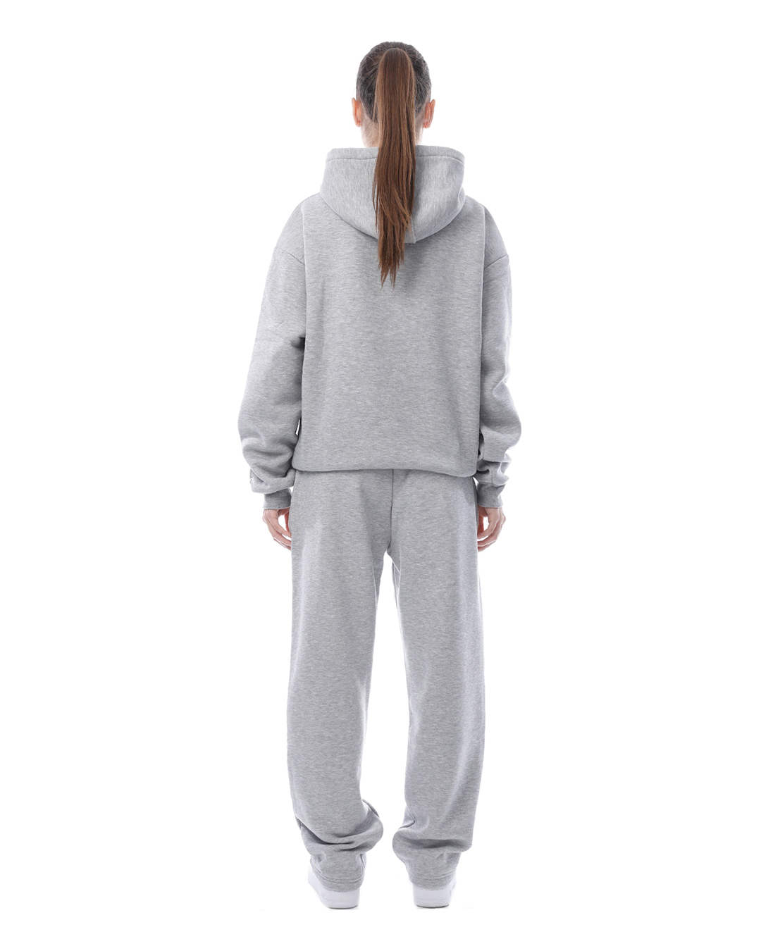 Frau in grauem Jogginganzug von hinten, Kapuzenpullover und Jogginghose, lässige Sportbekleidung, Freizeitmode, bequeme Kleidung.