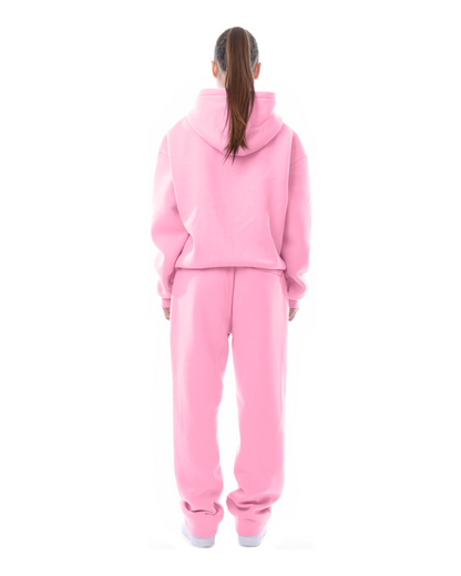 Frau in rosa Hoodie und Jogginghose, Rückansicht. Bequeme Freizeitkleidung, sportlicher Look, modischer Streetwear-Stil.