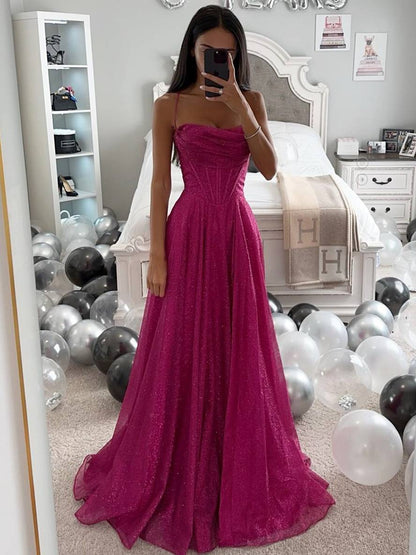 Frau in pinkfarbenem Abendkleid vor Spiegel, umgeben von schwarz-weißen Luftballons im Schlafzimmer. Elegantes, glitzerndes Ballkleid.