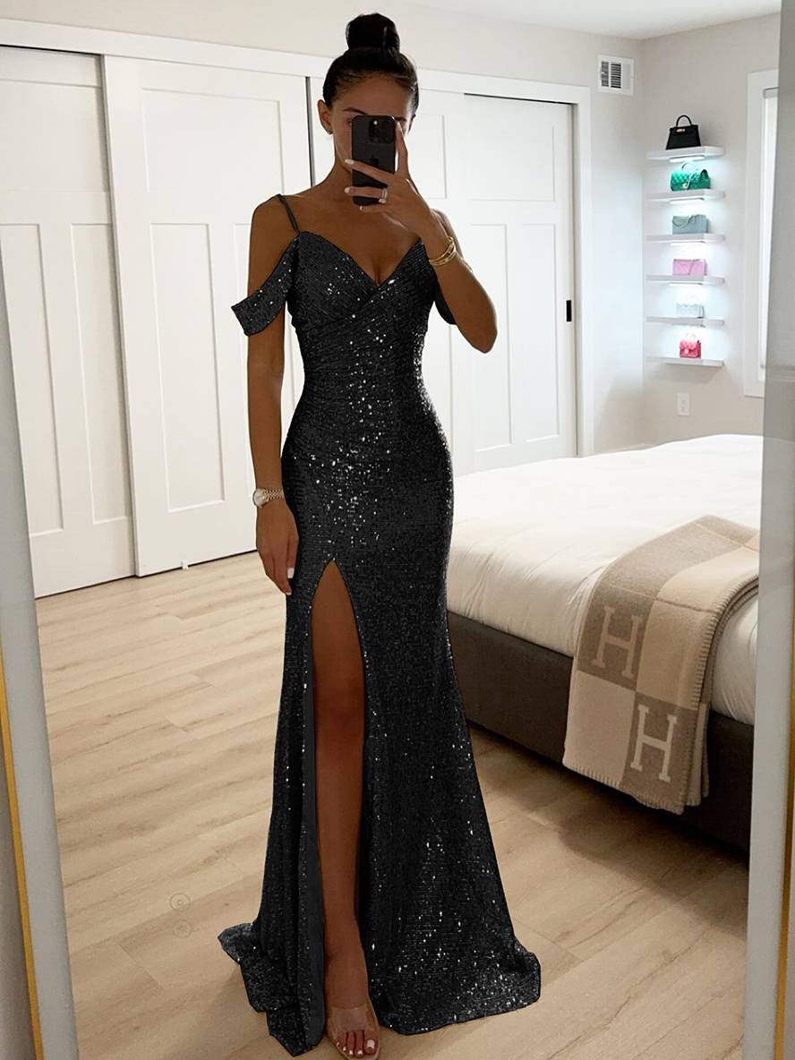 Frau in elegantem, schwarzem Paillettenkleid mit hohem Schlitz, steht in modernem Schlafzimmer. Abendmode, glamouröses Kleid, Modefotografie.