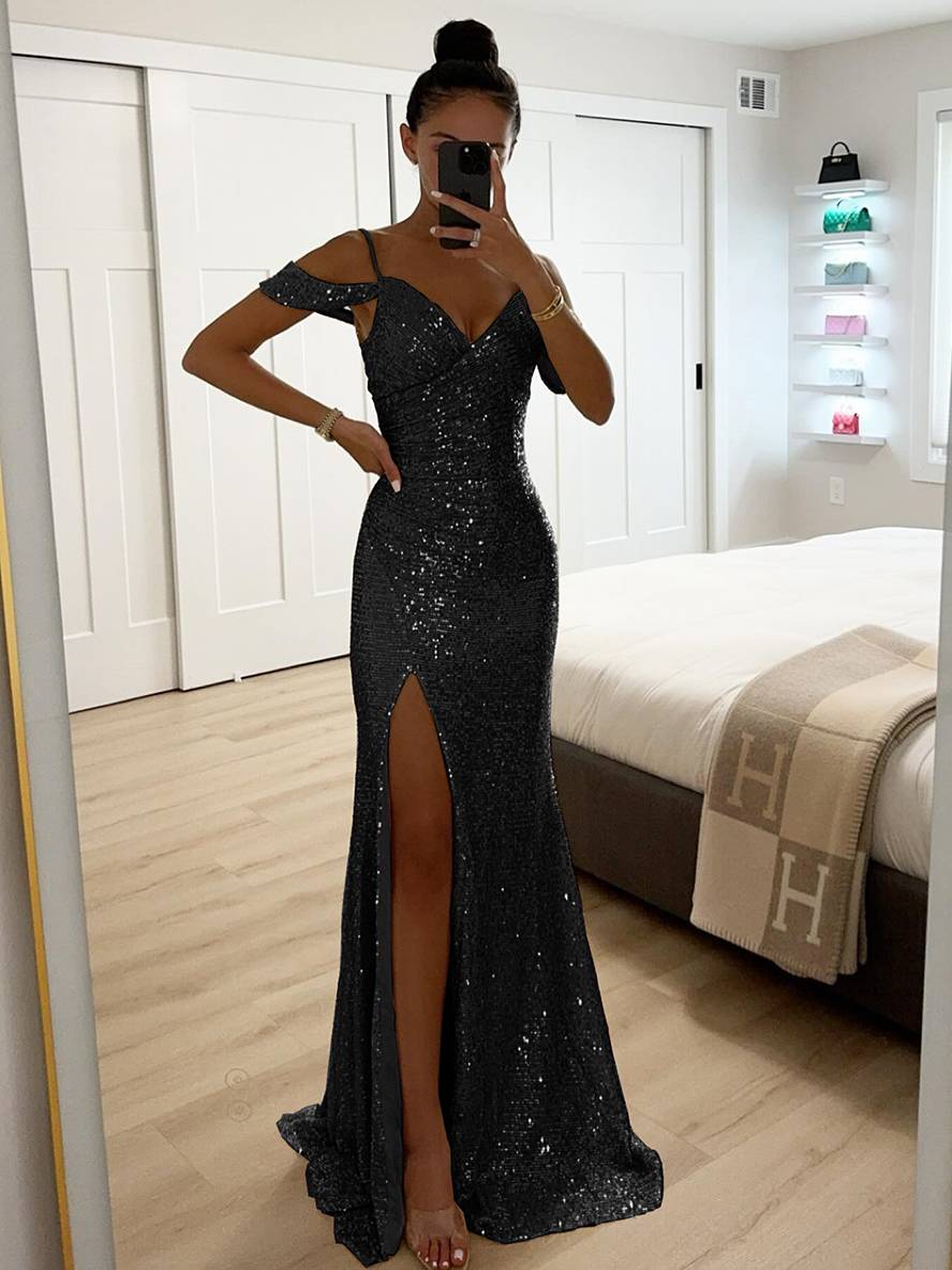 Frau in schwarzem, schulterfreiem Paillettenkleid mit hohem Schlitz, steht in modernem Schlafzimmer, Spiegel-Selfie, elegantes Abendmode-Outfit.