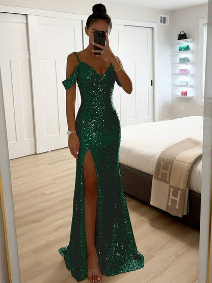 Frau im grünen Paillettenkleid mit Schlitz, fotografiert in modernem Schlafzimmer. Elegantes Abendkleid, glamouröse Mode, stilvolle Abendgarderobe.