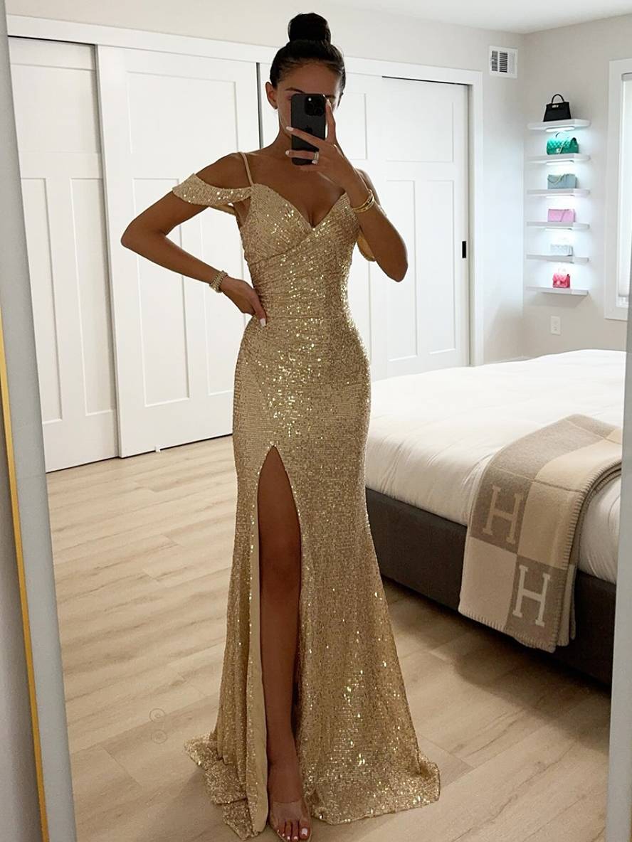 Frau in goldenem Paillettenkleid mit hohem Beinschlitz, elegantes Abendkleid, Spiegel-Selfie, modernes Schlafzimmer, glamouröse Mode.