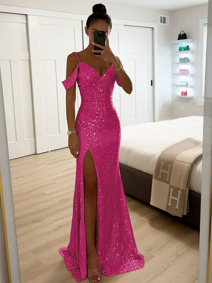 Frau in pinkem, glitzerndem Abendkleid mit hohem Beinschlitz, steht in modernem Schlafzimmer, macht Selfie im Spiegel. Elegantes, modisches Outfit.