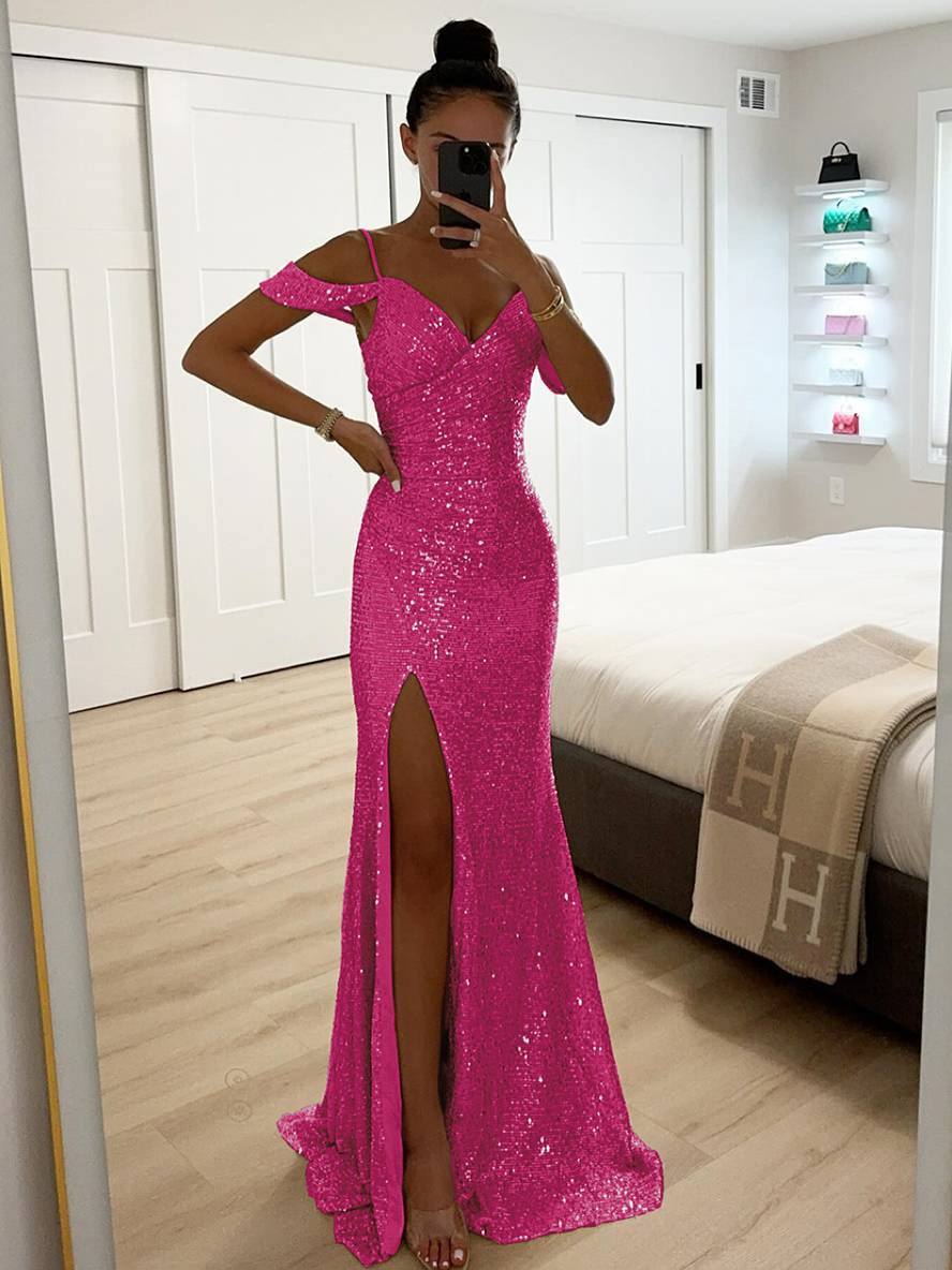 Frau in pinkem Paillettenkleid mit Schlitz, fotografiert in modernem Schlafzimmer. Elegantes Abendkleid, glamouröser Look, Mode für besondere Anlässe.