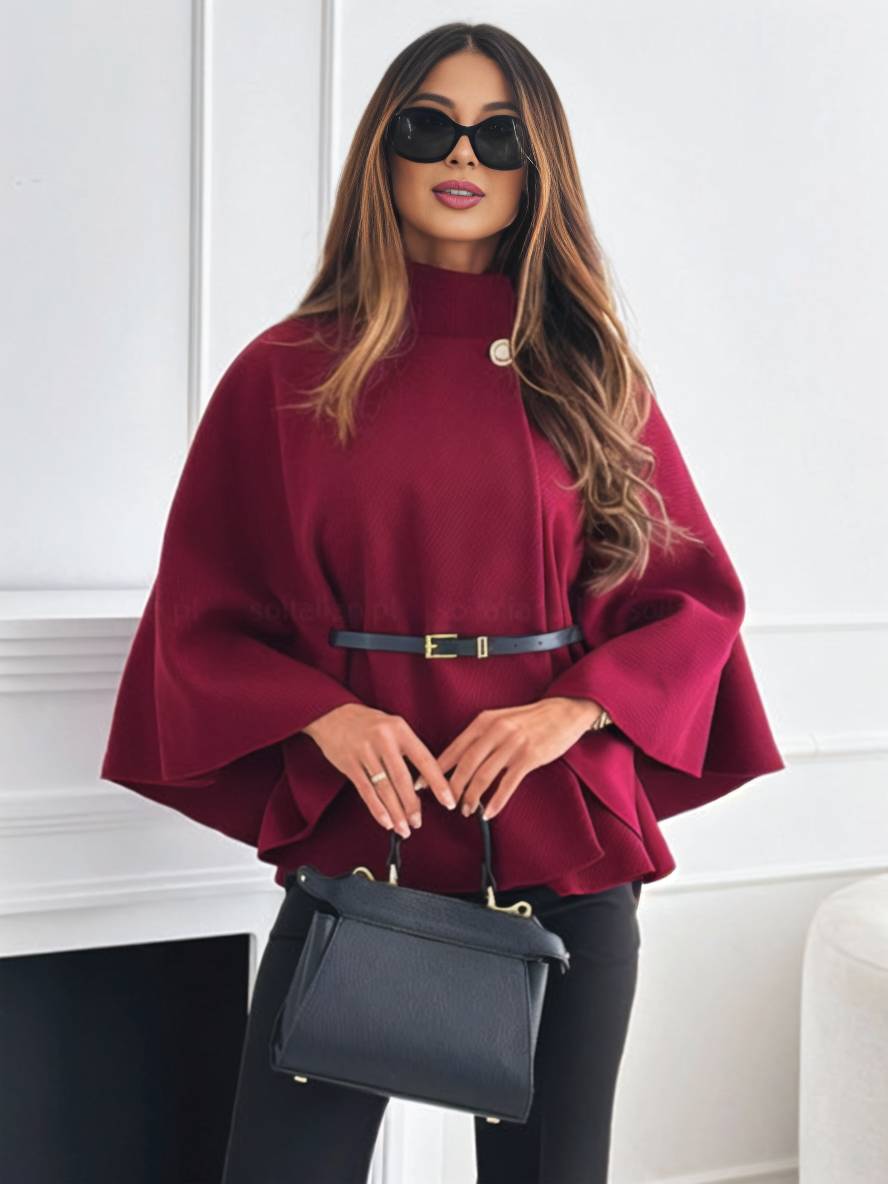 Frau in rotem Cape mit Gürtel, schwarzer Sonnenbrille und schwarzer Handtasche vor weißer Wand. Elegante Mode, Herbstoutfit, stilvolle Accessoires.