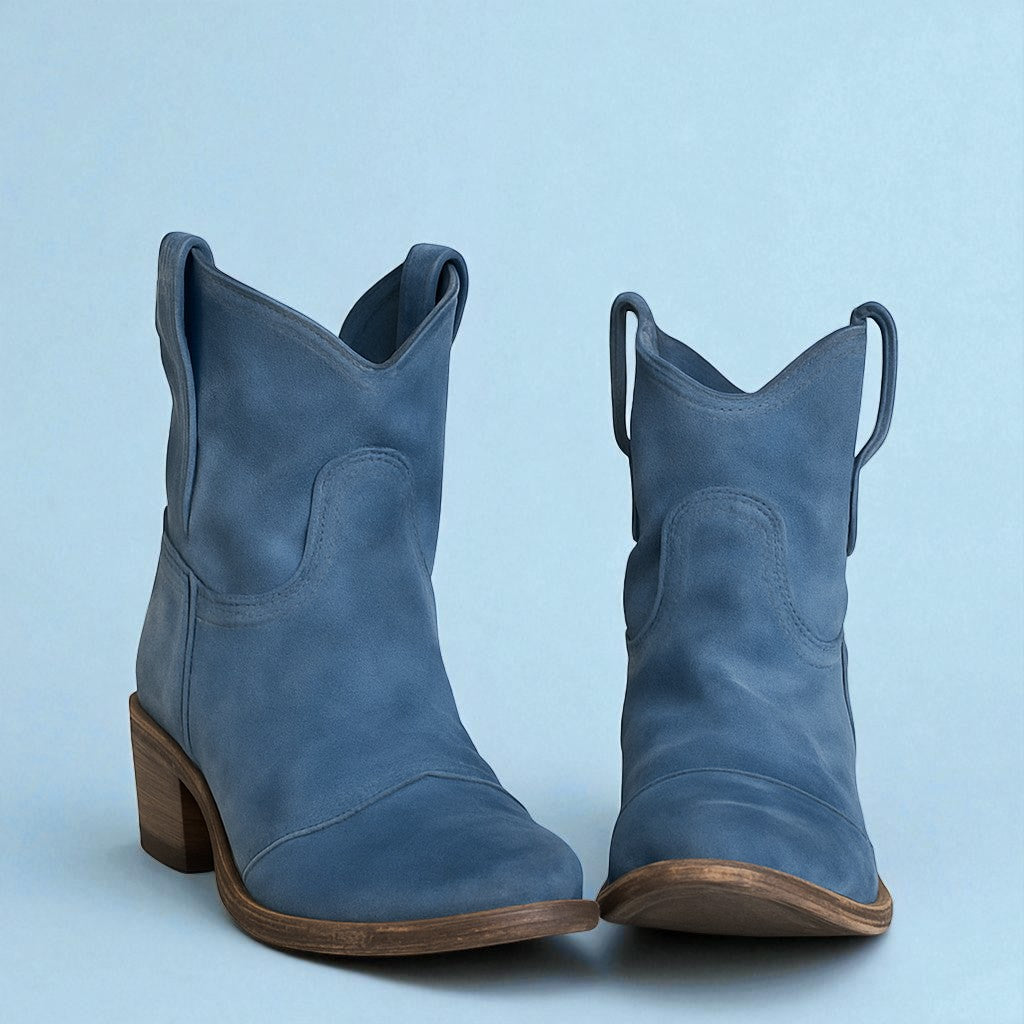 Blaue Cowboystiefel aus Leder mit Holzabsatz vor blauem Hintergrund. Modische Westernstiefel für Damen, ideal für trendige Outfits.