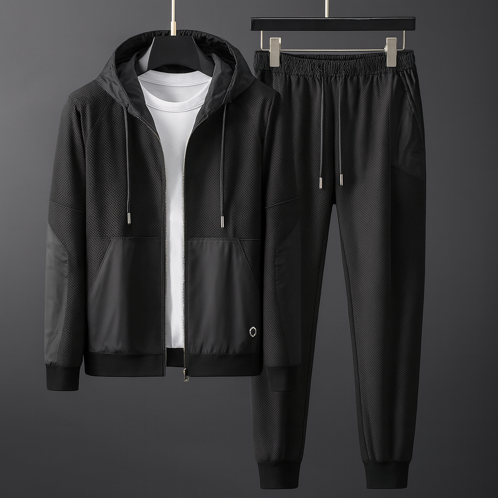 Schwarzer Trainingsanzug mit Kapuzenjacke und Jogginghose, aus atmungsaktivem Material, ideal für Sport und Freizeit, auf grauem Hintergrund.