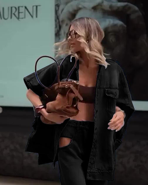 Blonde Frau in schwarzer Mode mit braunem Lederrucksack, Sonnenbrille und lockigem Haar. Urbaner Hintergrund, stilvoller Streetstyle-Look.