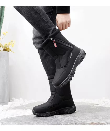 Schwarze Winterstiefel mit Reißverschluss, rutschfeste Sohle, getragen von Person in Jeans. Ideal für Outdoor-Aktivitäten bei kaltem Wetter.