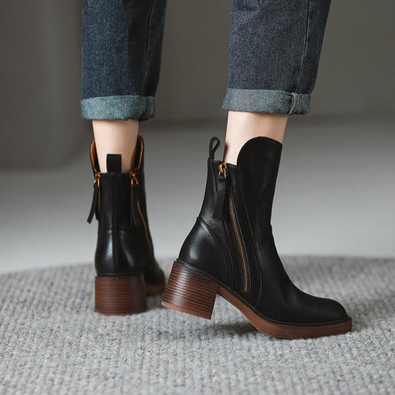 Schwarze Lederstiefeletten mit Blockabsatz und Reißverschluss, getragen mit hochgekrempelten Jeans. Modische Damenstiefel für Herbst/Winter.