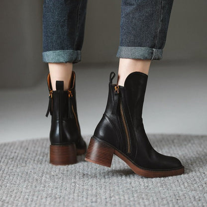 Schwarze Lederstiefeletten mit Blockabsatz und Reißverschluss, getragen mit hochgekrempelten Jeans. Modische Damenstiefel für Herbst/Winter.
