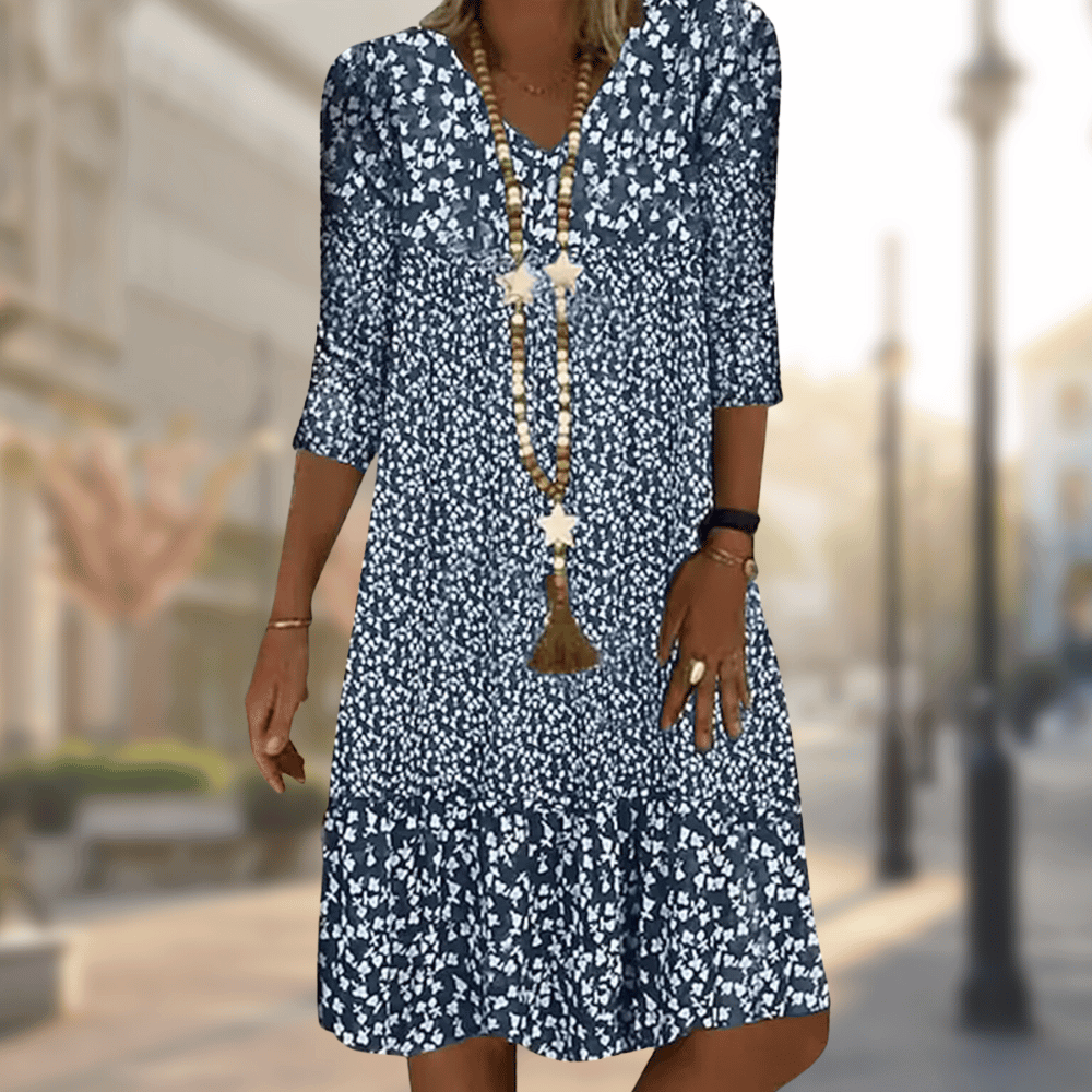 Dame in geblümtem Sommerkleid auf städtischer Straße. Modetrend 2023, lässiger Stil, blau-weißes Muster, elegantes Design, Freizeitmode.