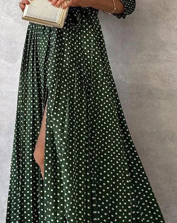 Grünes gepunktetes Maxikleid mit Beinschlitz, kombiniert mit einer kleinen, gestreiften Clutch. Elegantes Damenoutfit für besondere Anlässe.