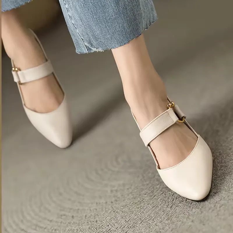 Beige Damen-Ballerinas mit Riemen, spitze Zehen, kombiniert mit blauen Jeans. Modische, elegante Schuhe für Alltag und Büro.