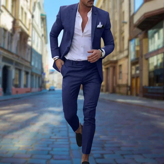Eleganter Mann im blauen Anzug läuft auf gepflasterter Straße, modischer Stil, urbane Umgebung, Business-Look, Herrenmode, Stadtbild.