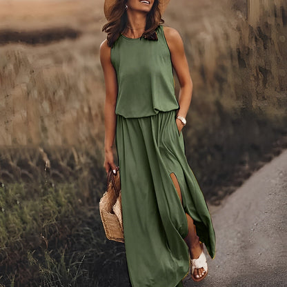 Frau in grünem Maxikleid mit Schlitz, Strohhut und Sandalen spaziert auf ländlichem Weg. Sommermode, Freizeitkleidung, Natur.