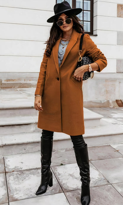 Frau in braunem Mantel, schwarzem Hut und Stiefeln auf Treppe. Modischer Herbstlook, stilvolle Accessoires, urbane Eleganz.