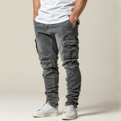 Graue Cargo-Hose für Herren, kombiniert mit weißen Sneakern und weißem T-Shirt. Modische Freizeitkleidung, ideal für urbanen Stil.
