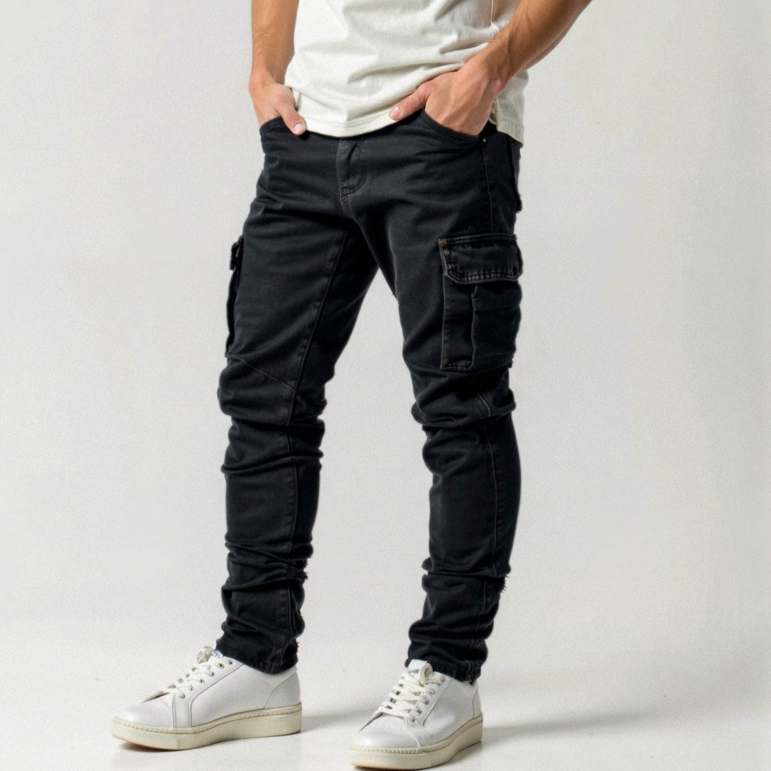 Mann trägt schwarze Cargohose und weiße Sneaker, lässiger Stil, Mode für Herren, Freizeitkleidung, moderne Streetwear, trendige Hosen.